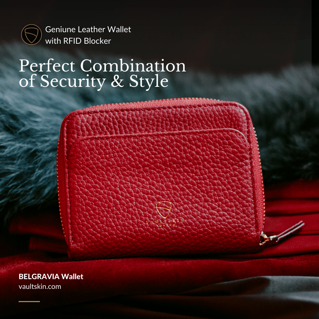 A red leather zip-around wallet with an embossed logo sits on red fabric against a dark feathery background