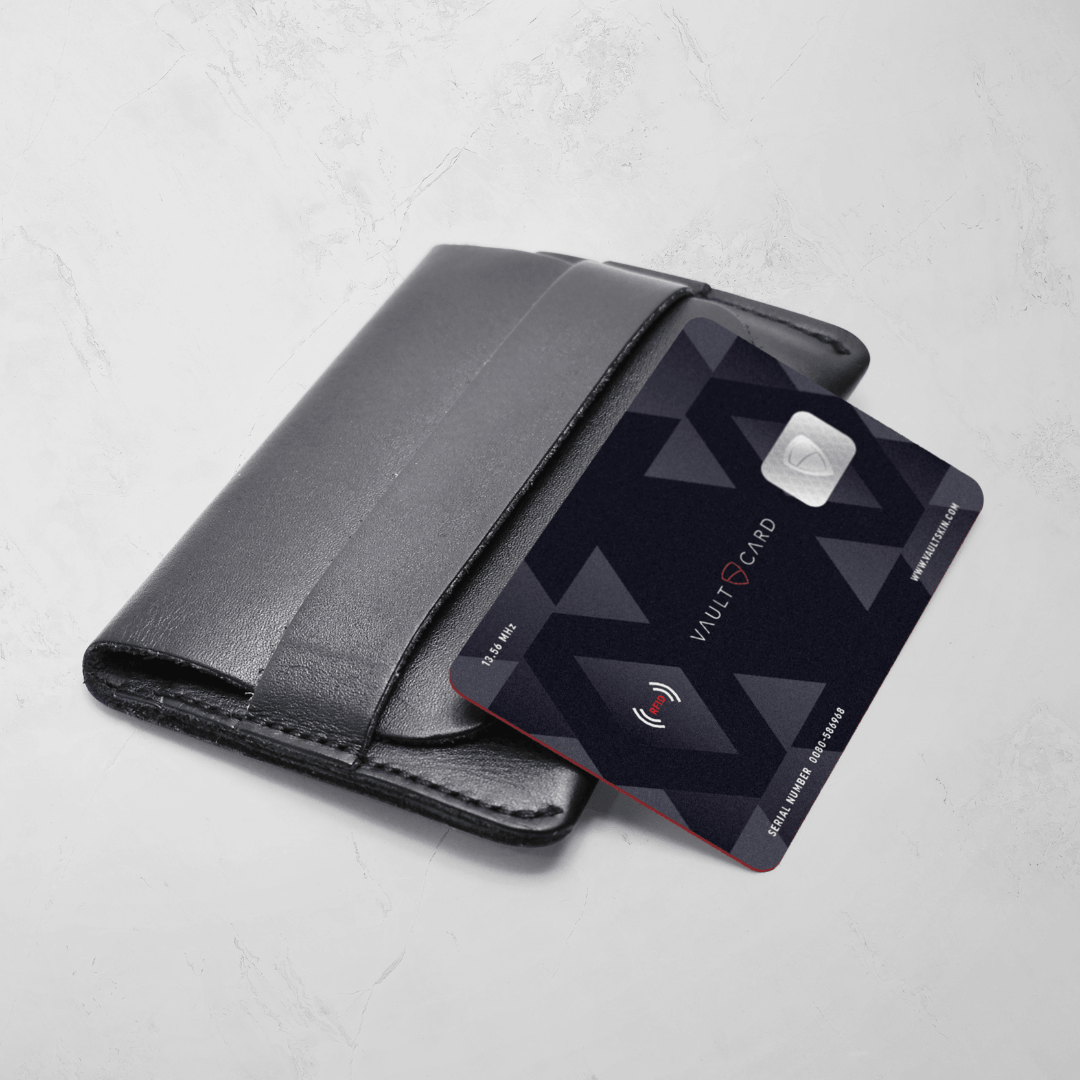 VAULTCARD rests against a black leather card holder on a marble surface