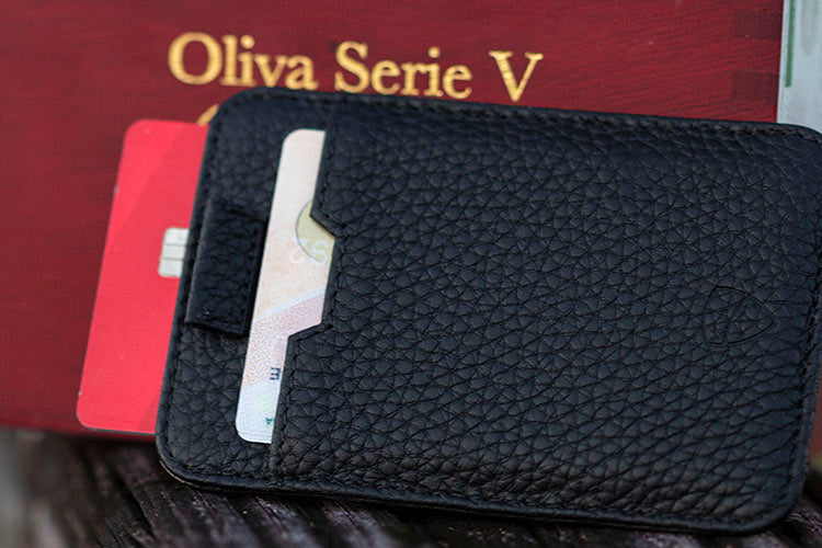 Black leather CHELSEA wallet holding 2 cards beside a cigar box