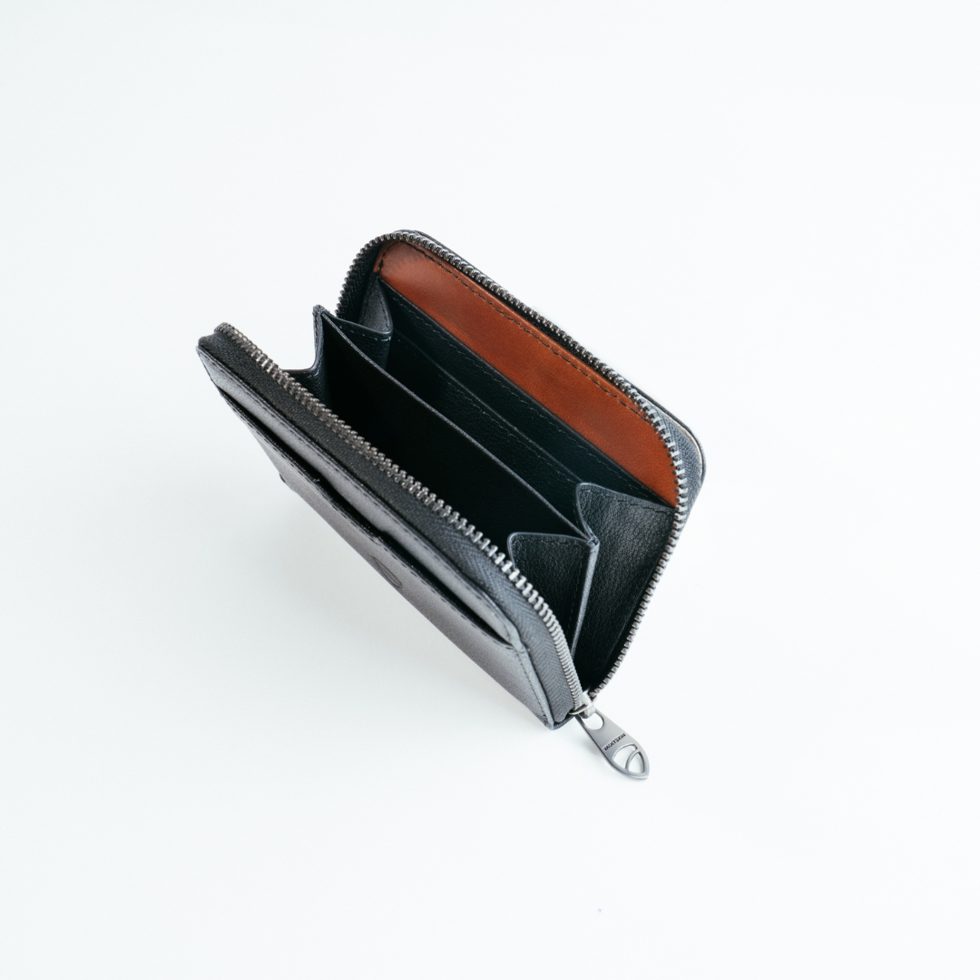 Open black leather zip wallet with a tan interior and multiple card slots