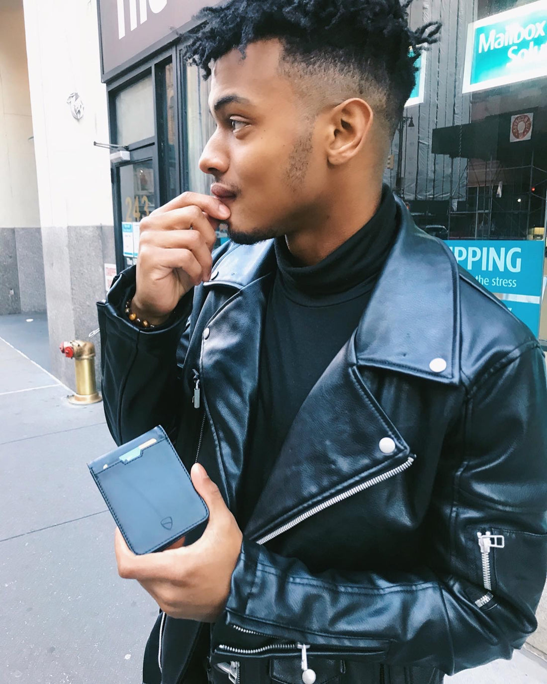 Man holding Manhattan wallet out on a street in New York City