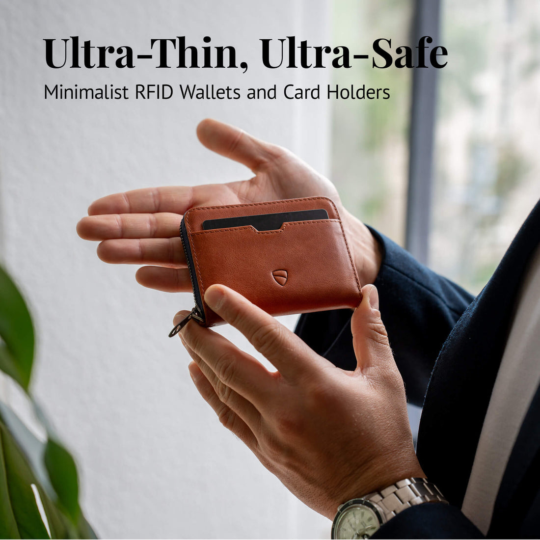 A man holds an open tan leather zip-around card holder with a zipper pull between both hands