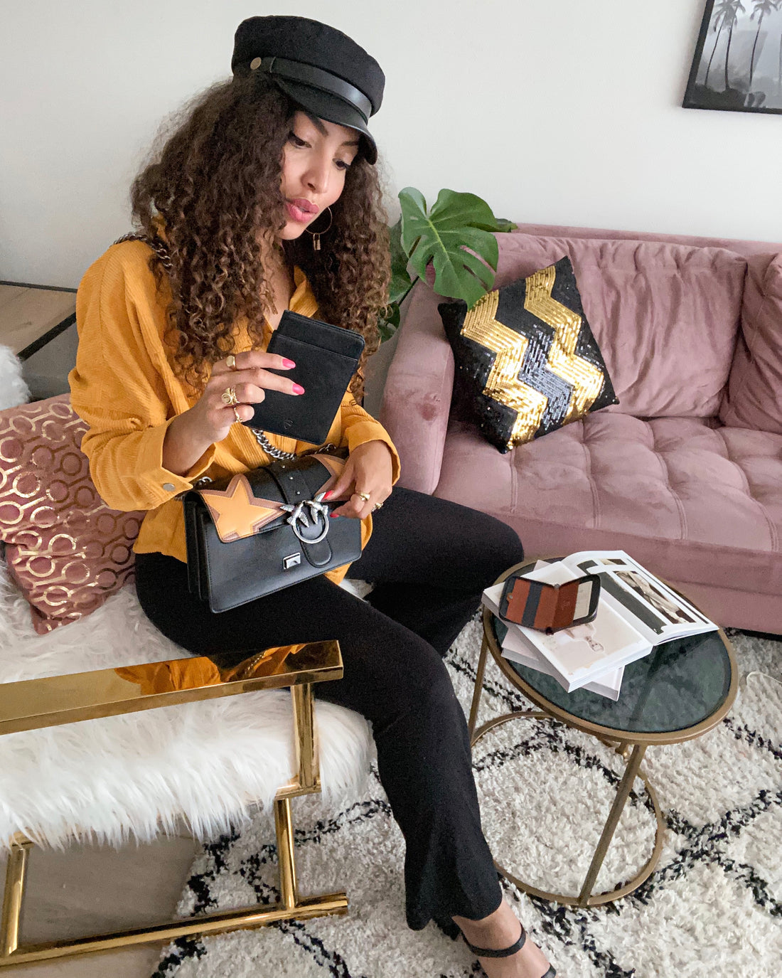 Woman in an armchair holds a wallet in her right hand and admires it