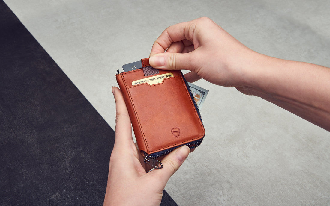 Two hands holding a zipper wallet