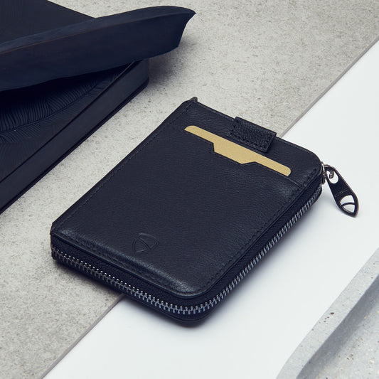 Vaultskin Notting Hill zipper wallet in black RFID protected lies on a table