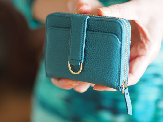 Woman holding the Vaultskin Belgravia zip wallet RFID protected in turquoise