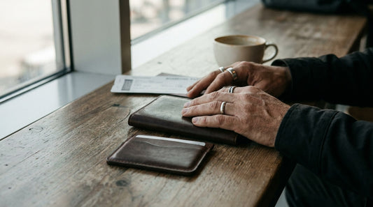 Closed leather passport holder and cardholder on a table in an airport lounge, softly lit by window light