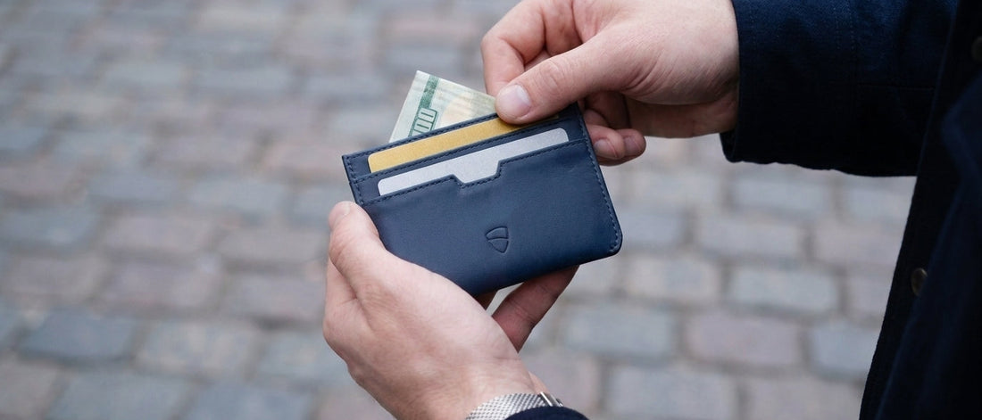 Vaultskin Moorgate minimalist leather cardholder in hand of the man with credit and debit cards and cash